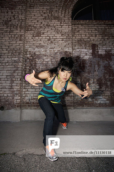 Chinesische Frau beim Breakdance im Stadtgebiet