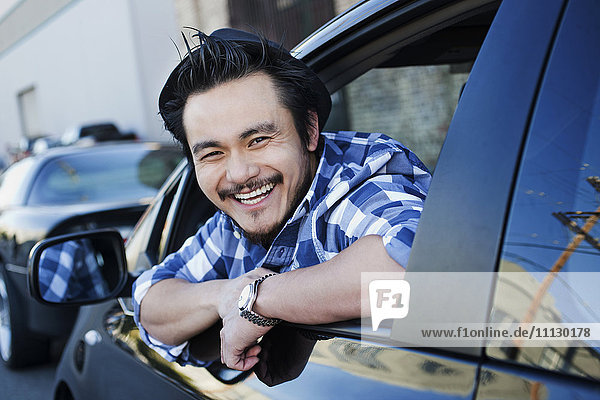 Smiling mixed race man in compact car