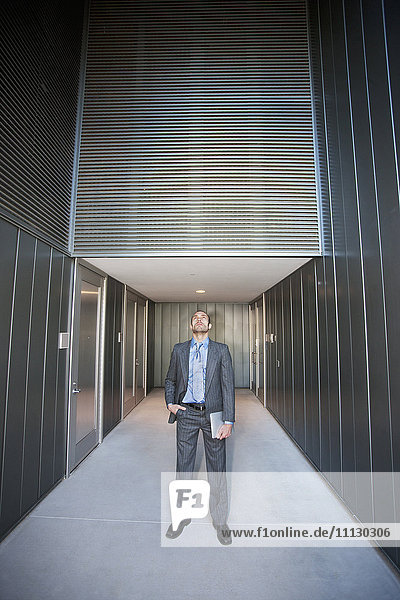 Businessman holding digital tablet in corridor
