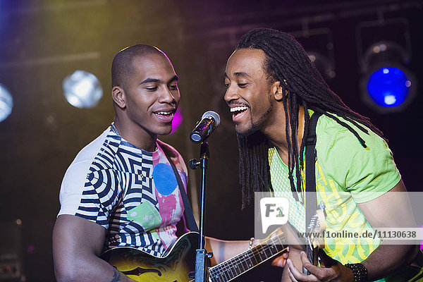 African men singing and playing guitar onstage