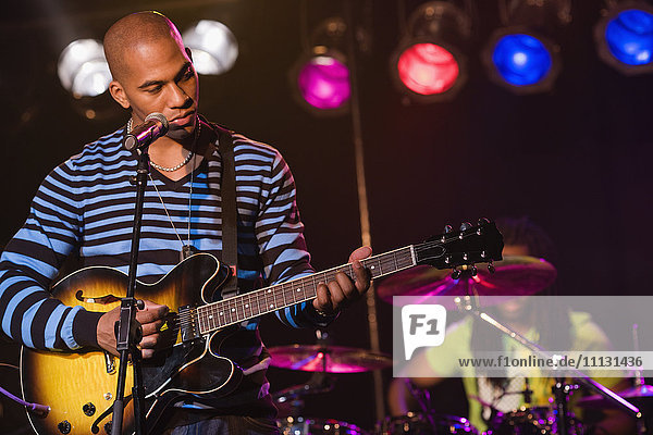 African man playing electric guitar onstage