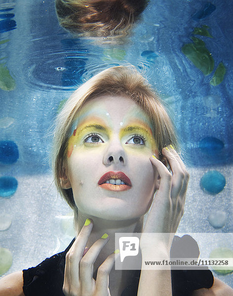 Kaukasische Frau mit Make-up unter Wasser