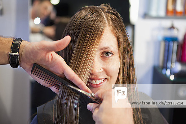 Woman having haircut in salon