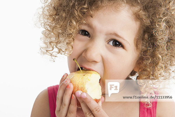 Gemischtrassiges Mädchen isst Apfel