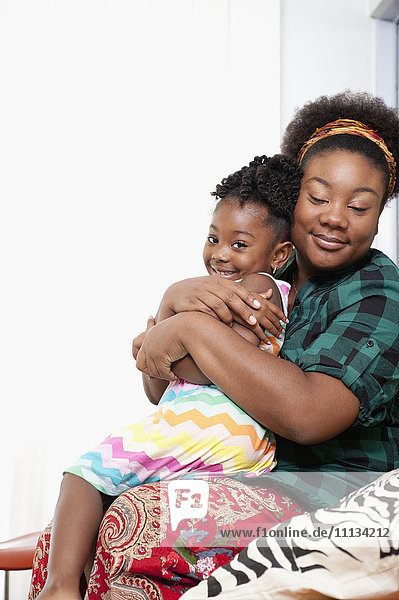 African American mother holding daughter on lap