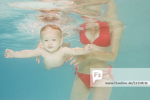 Kaukasisches Baby schwimmt unter Wasser