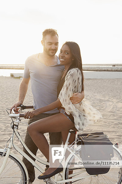 Couple with bicycle on beach