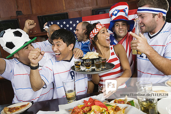 Sports fans drinking and eating in sports bar