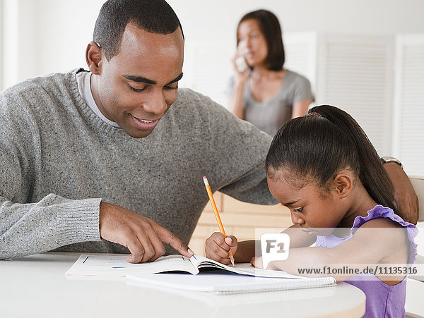 Afroamerikanischer Vater hilft seiner Tochter bei den Hausaufgaben