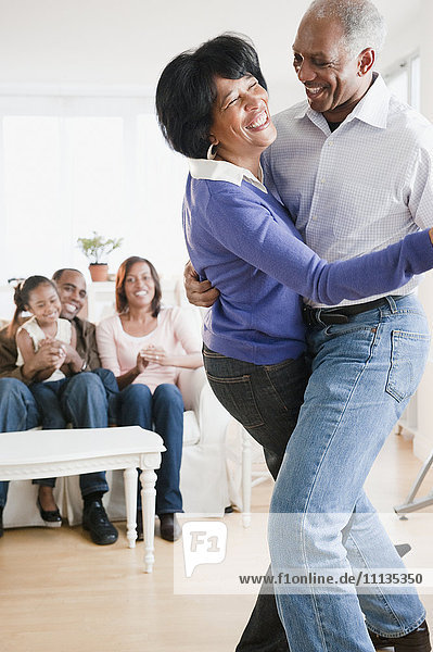 African American man dancing with wife in living room