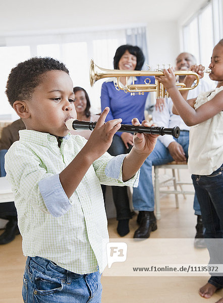 African American family watching children play instruments