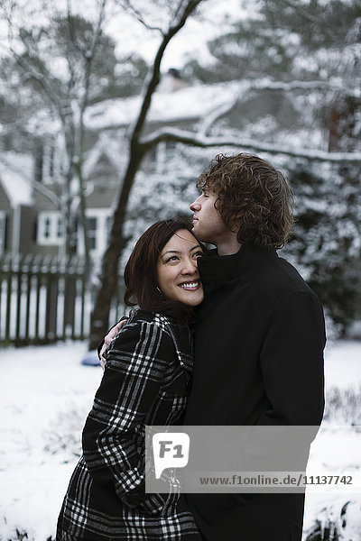 Paar  das sich im Freien im Schnee umarmt