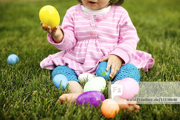 Gemischtrassiges Mädchen spielt mit Ostereiern
