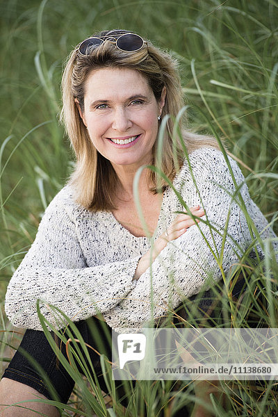Caucasian woman sitting in tall grass