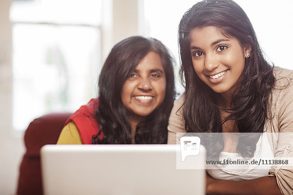 Indische Mutter und Tochter benutzen gemeinsam einen Laptop