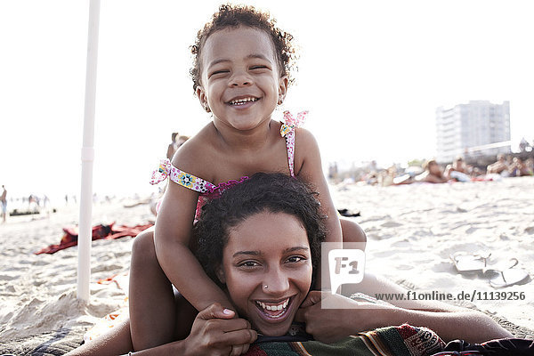Gemischtrassige Mutter und Tochter genießen den Strand