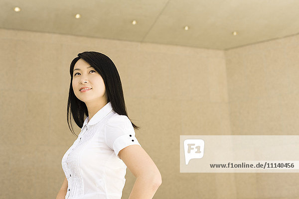 Lächelnde chinesische Geschäftsfrau im Büro