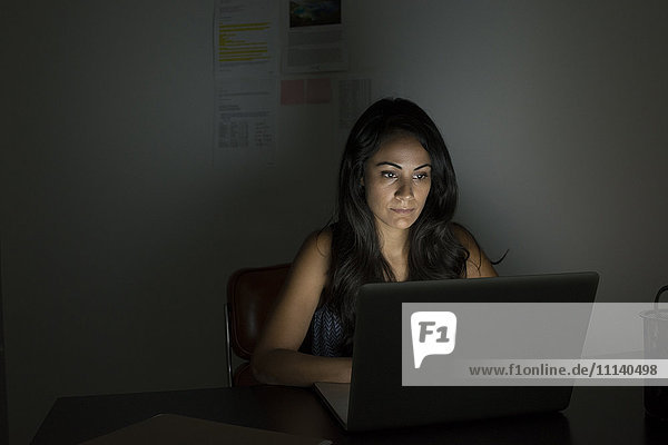 Geschäftsfrau arbeitet nachts am Laptop