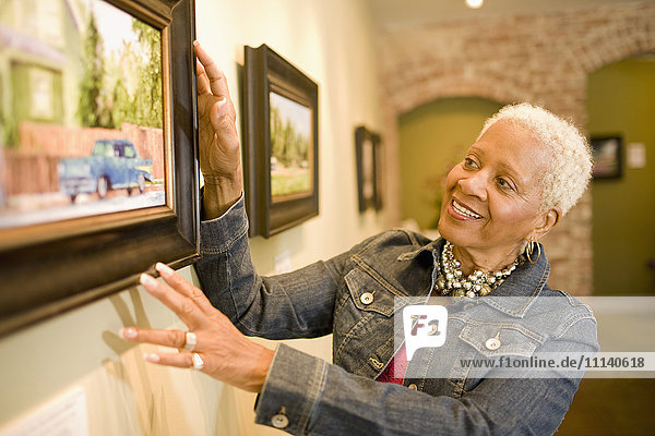 Schwarze Frau bewundert Gemälde in einer Galerie