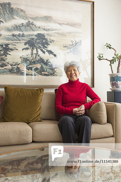 Chinesische Frau auf Sofa sitzend