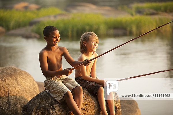Smiling boys fishing together