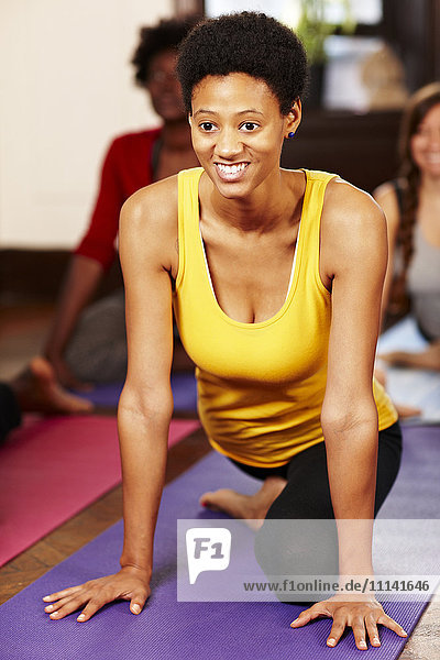 Black woman practicing yoga in class