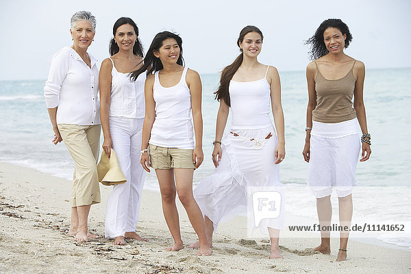 Unterschiedliche Frauen stehen gemeinsam am Strand