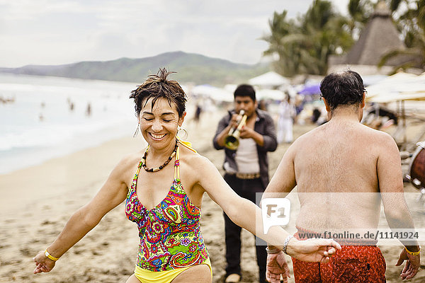 Hispanic people enjoying music on beach