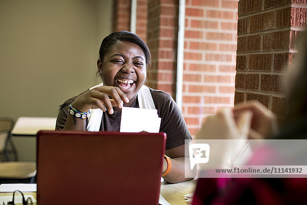 Lachende afroamerikanische Frau im Café sitzend