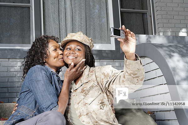 Schwarze Mutter nimmt Selbstporträt mit Soldatentochter auf