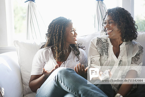 Black mother and daughter watching television together