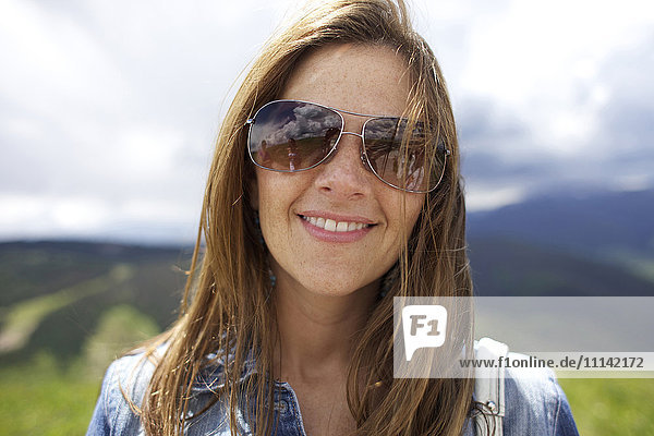 Smiling woman wearing sunglasses outdoors