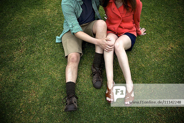 Paar sitzt zusammen im Gras