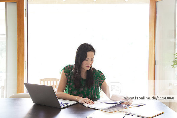 Korean woman paying bills on laptop