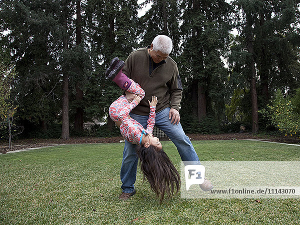 Vater und Tochter spielen im Hinterhof