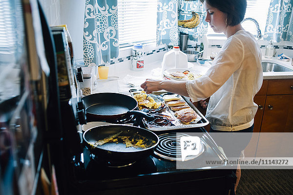 Frau kocht Frühstück in der Küche