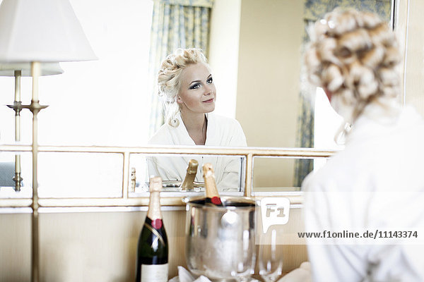 Caucasian woman admiring her hair in mirror