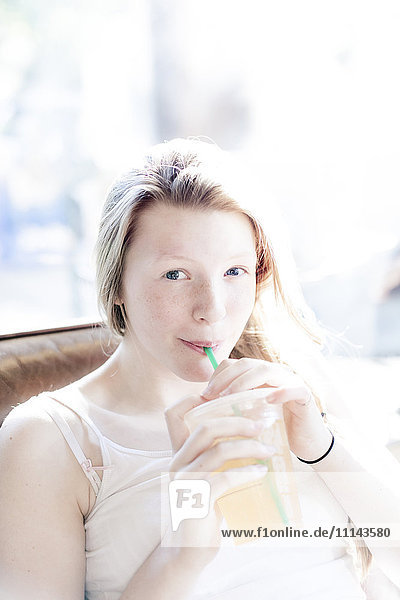 Smiling girl drinking iced tea