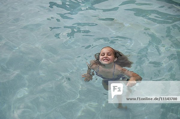 Kaukasisches Mädchen schwimmt im Pool