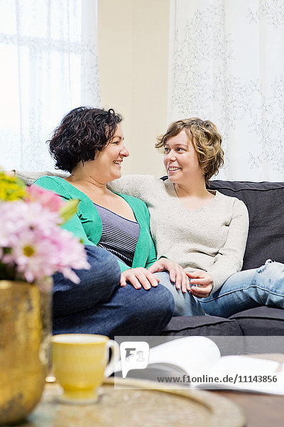 Lesbisches Paar entspannt sich auf dem Sofa im Wohnzimmer