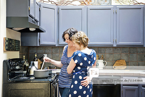 Lesbian couple cooking in kitchen