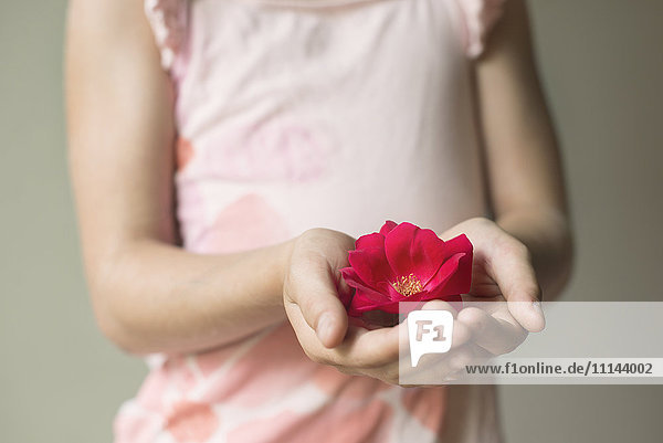 Kaukasisches Mädchen hält blühende Blume