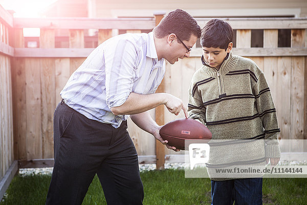 Hispanischer Vater bringt seinem Sohn das Fußballspielen bei