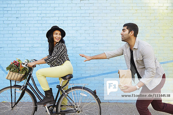 Indischer Mann jagt Freundin auf dem Fahrrad