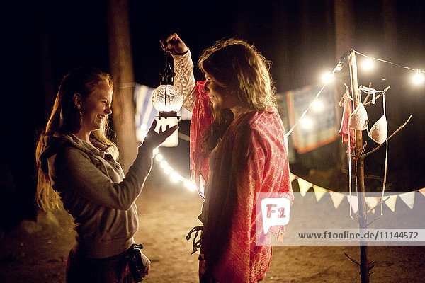 Mädchen mit Laterne auf dem Campingplatz bei Nacht