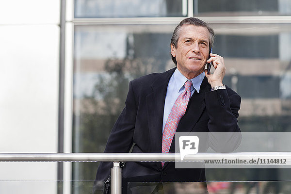 Caucasian businessman on cell phone on balcony