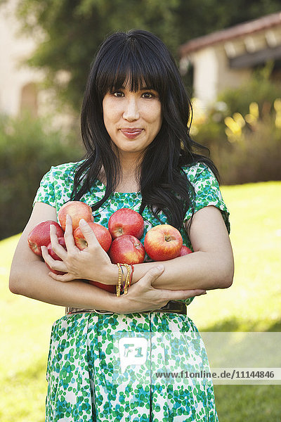 Woman holding armfuls of fruit
