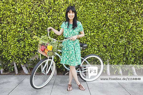 Woman carrying produce in bicycle basket