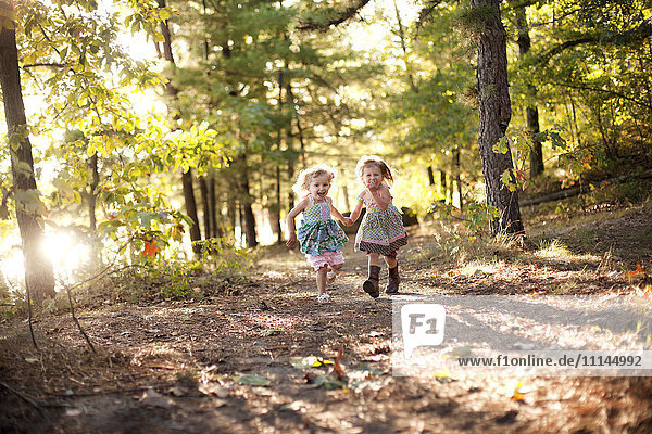 Mädchen laufen auf einem Waldweg