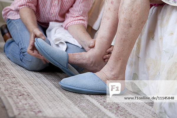 Pflegekraft hilft älterer Frau zu Hause
